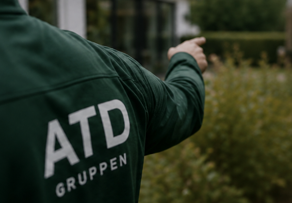 To ATD Gruppen medarbejdere ser ud over byggeplads i solnedgang